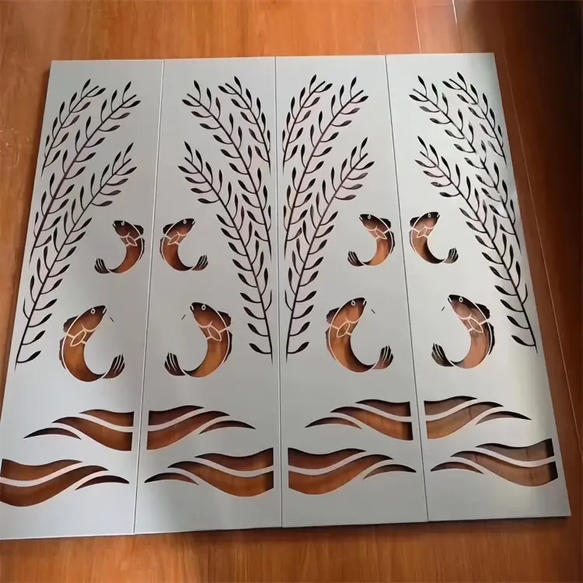 White decorative cut panel with a stylized tree and landscape pattern