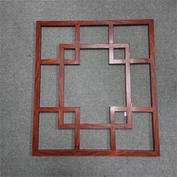 Wood-toned geometric grille frame displayed against a neutral background